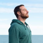 man with anxiety who is now calm and standing at the ocean