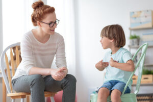 Woman sitting talking to a boy during his autism treatment