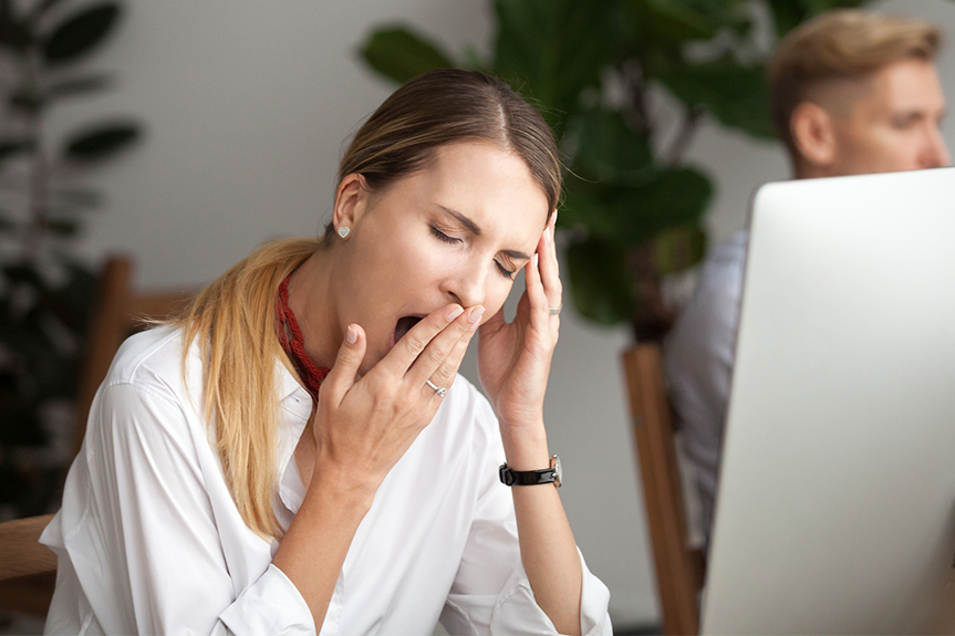 woman at computer who's tired from lack of sleep