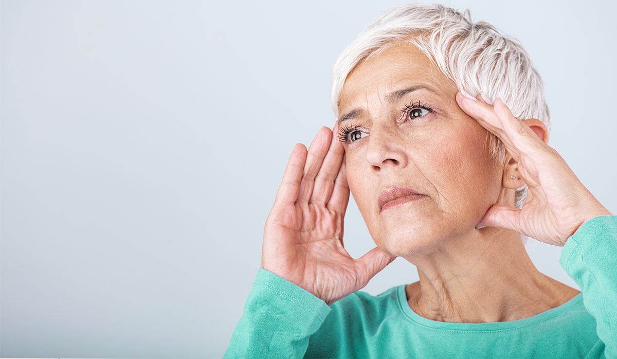 woman with memory loss holding her head