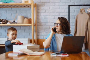 Mom on phone with kid next to her, playing