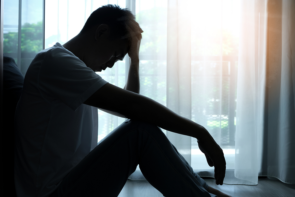 man with treatment-resistant depression alone in a dark room